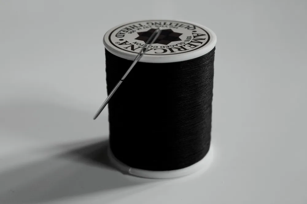 Nadel, Faden und Garnrolle – Detail aus dem Schneiderhandwerk